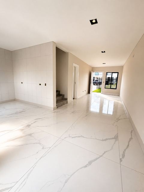 Hall de entrada com piso porcelanato e escada